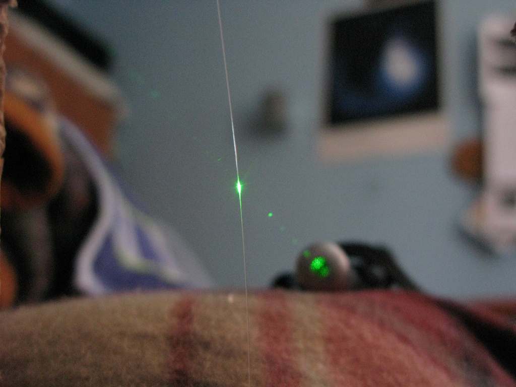 Laser xanh chiếu vào một sợi quang mỏng