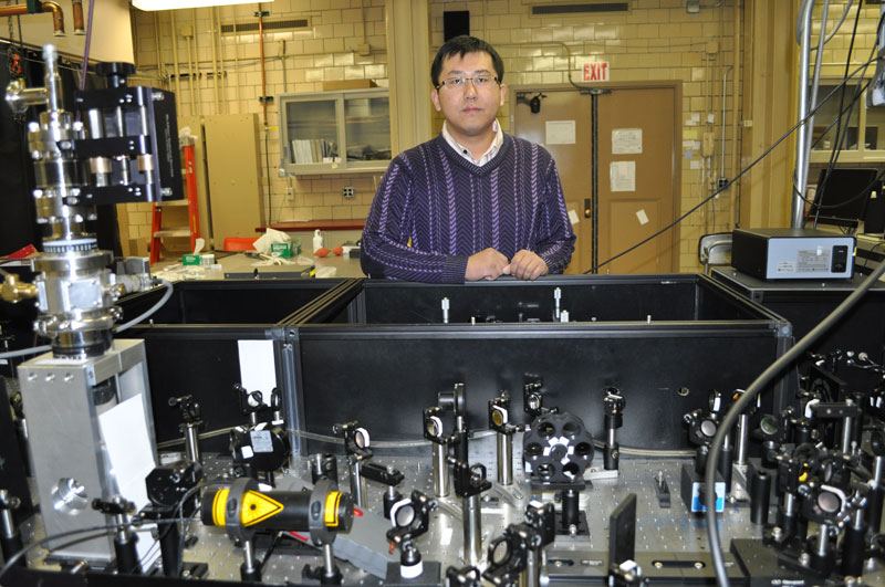 Jigang Wang đứng trước thiết bị dùng trong các thí nghiệm