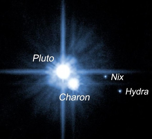 Đây là Pluto, cùng với ba vệ tinh được biết đầu tiên của nó. Các nhà thiên văn đã tìm thấy vệ tinh lớn nhất, Charon, vào năm 1978. 