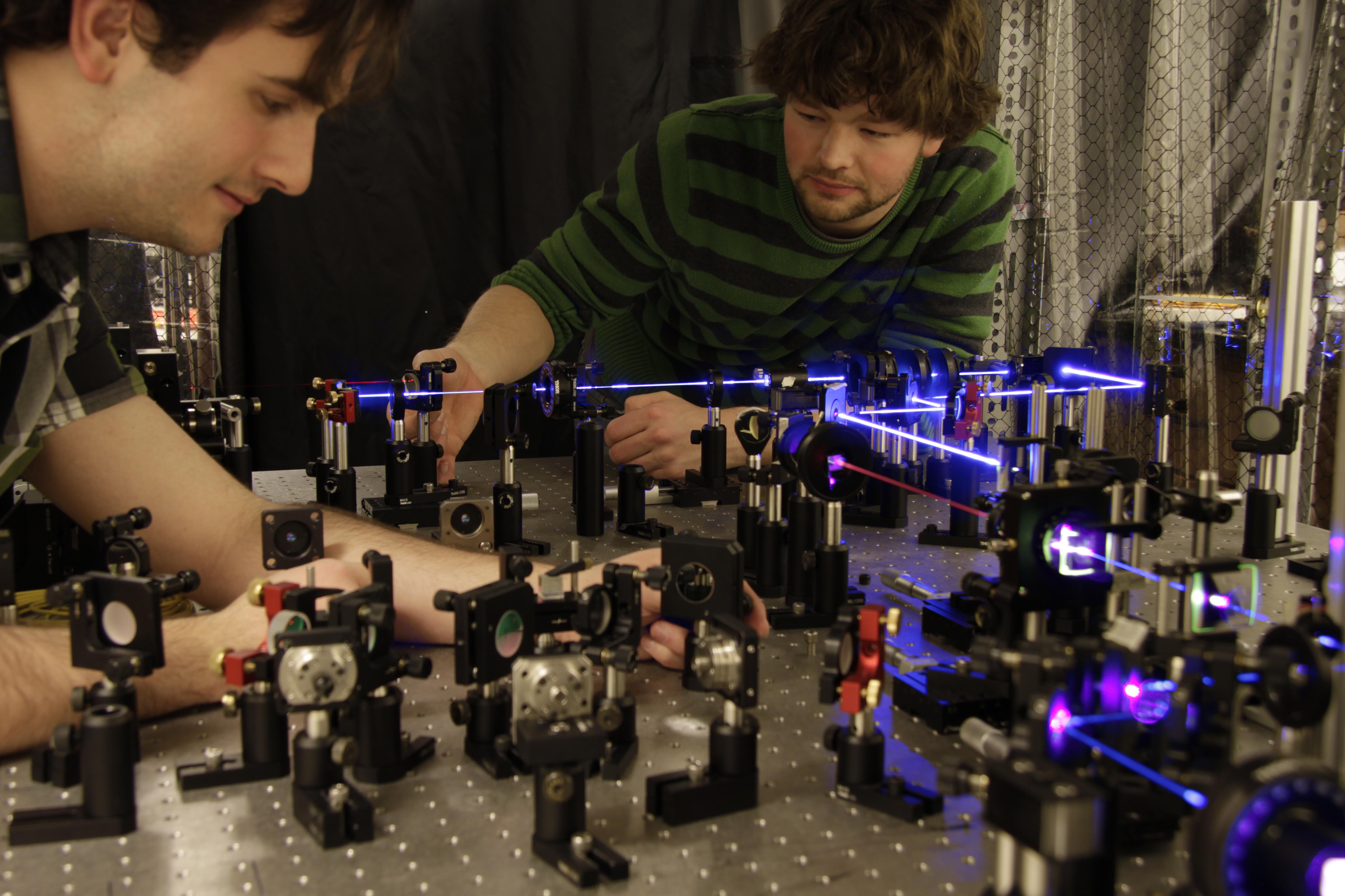 Các nghiên cứu sinh Dylan Mahler (trái) và Lee Rozema (phải) đang chuẩn bị các cặp photon vướng víu để nghiên cứu sự nhiễu loạn mà các photon đó chịu sau khi chúng bị đo
